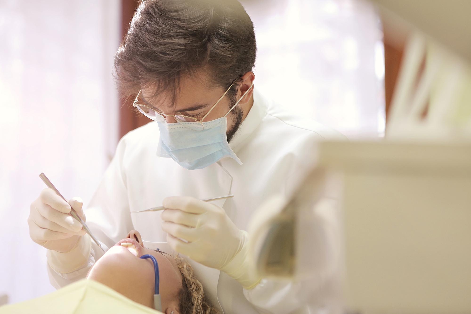 A dentist cleaning their patient's teeth